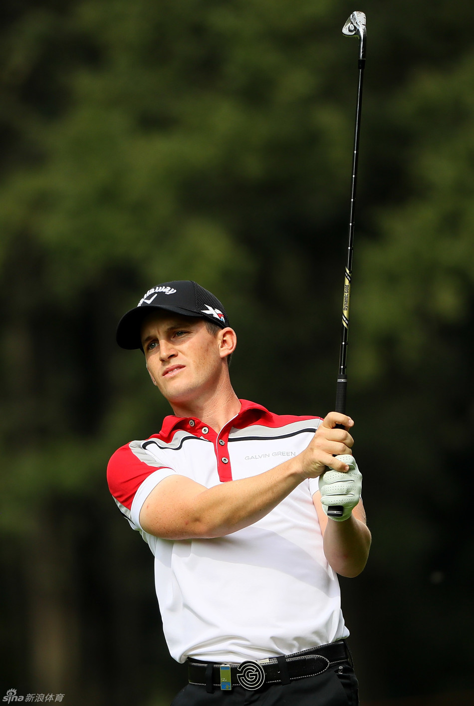 高尔夫球员在果岭上全神贯注地进行推杆，周围观众屏息凝神安静观赛