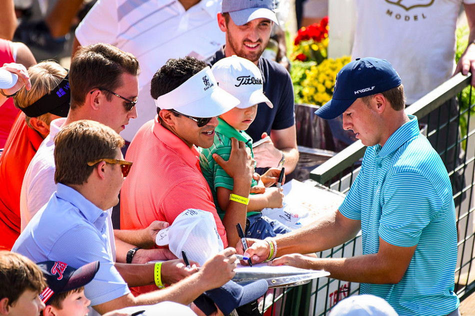 斯皮思弯下腰,耐心地为一位小球迷的高尔夫球帽签名,身旁其他粉丝满脸期待地注视着这一刻。