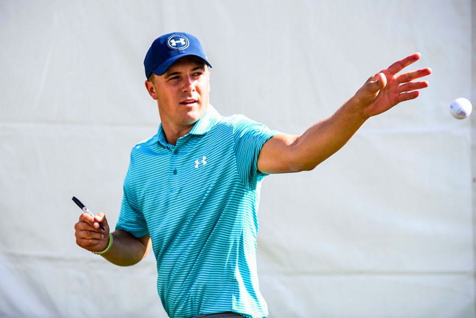 斯皮思与他的球童并肩走在球道上,两人正专注地讨论下一杆的策略,体现了赛场上的紧密合作与信任。