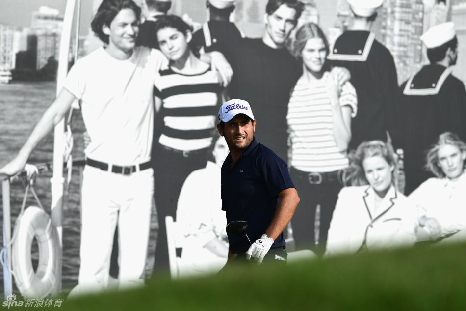 比赛现场，一位球童正为球员仔细擦拭高尔夫球杆，专注的神情体现了专业团队对细节的极致追求。