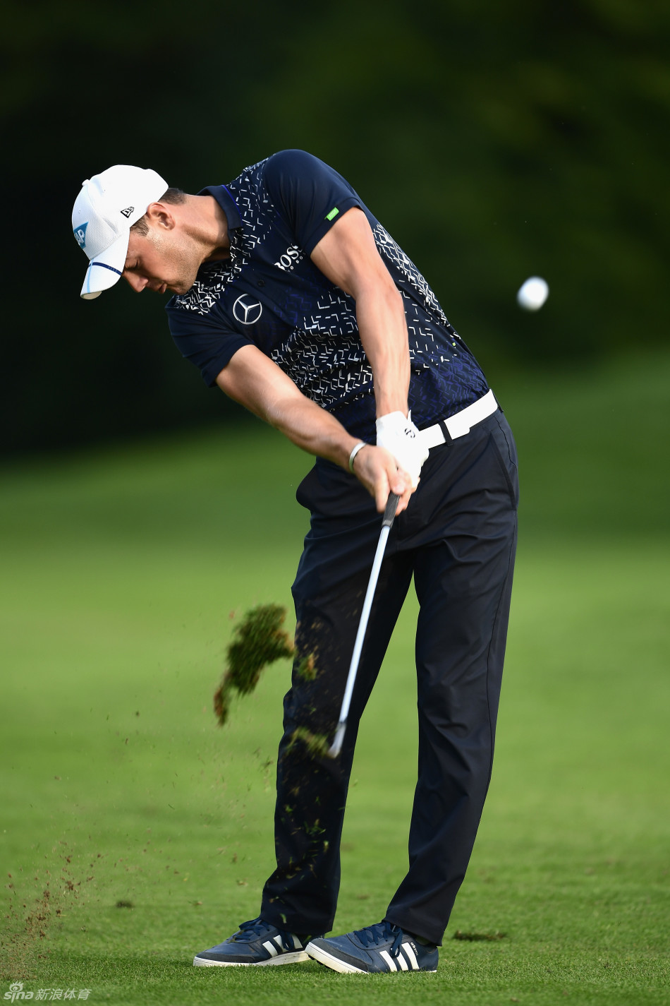 球员在发球台上全神贯注准备开球，背景是弥漫的晨雾与宁静的球场，构成一幅动静相宜的优美画面。