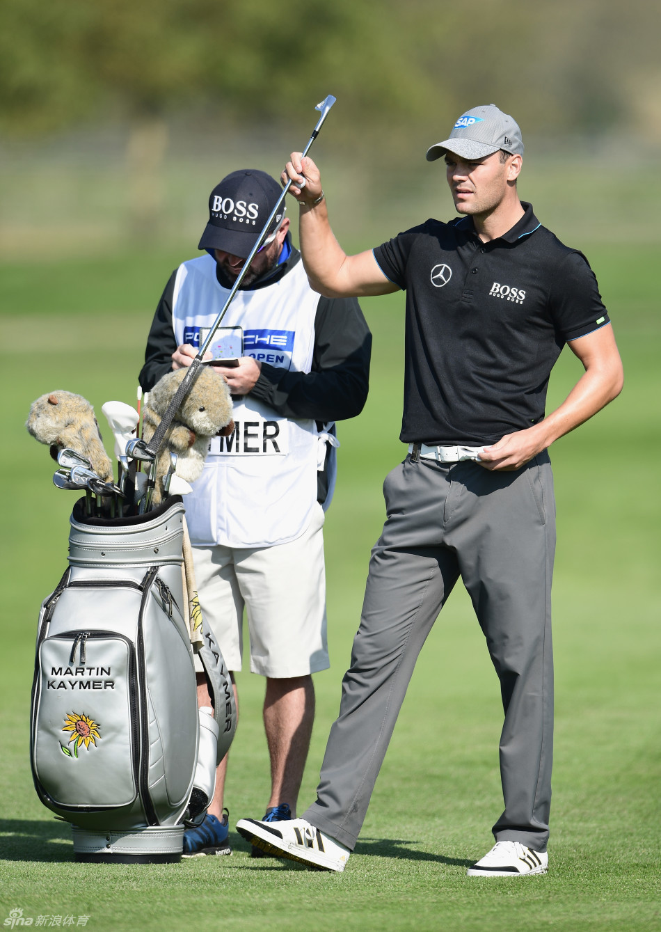 中国选手李昊桐在果岭边皱着眉头观察推杆线路，他脚边的雾气尚未完全散去，表情透露出面对挑战时的专注与思考。