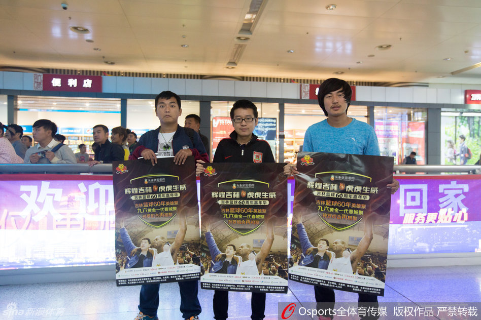 罗德将一名儿童搂在怀中，耐心地为孩子调整着球衣，孩子羞涩地摸着罗德的手臂，这画面仿佛是一种传承，象征着篮球火种的延续。