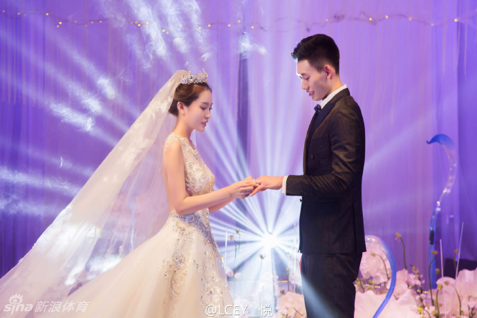 身披洁白婚纱的新娘手捧鲜花，与身穿深色礼服的新郎王镤在宴会厅内深情对视，眼中满是爱意与甜蜜