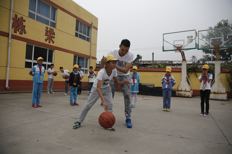 在尘土飞扬的简陋操场上，翟晓川亲自示范投篮动作，篮球在空中划出优美弧线，一群孩子仰头追随球的轨迹，眼中闪烁着对运动的热爱