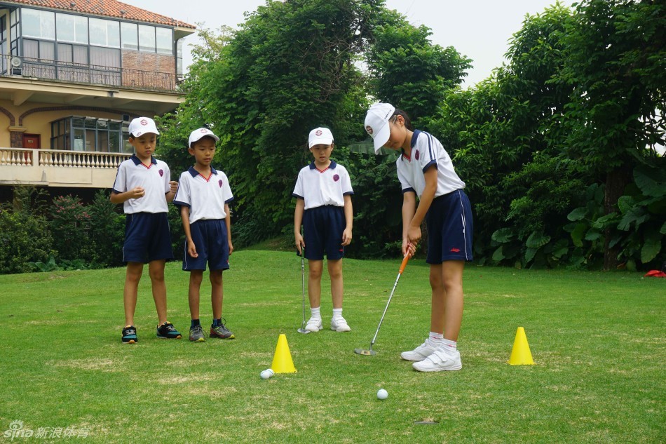 颁奖典礼上，身着优雅套装的女士弯腰将金色奖杯递给满脸自豪的小冠军，其他队员在旁边开心鼓掌