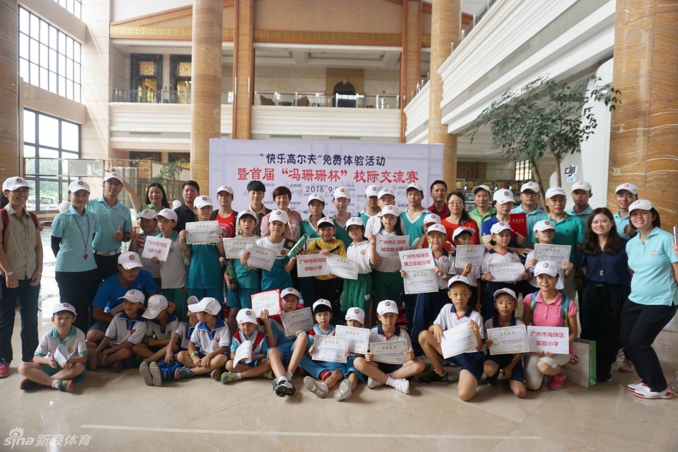 教练单膝跪地，手把手指导一名戴眼镜的学生调整握杆姿势，背景里其他孩子正在认真练习