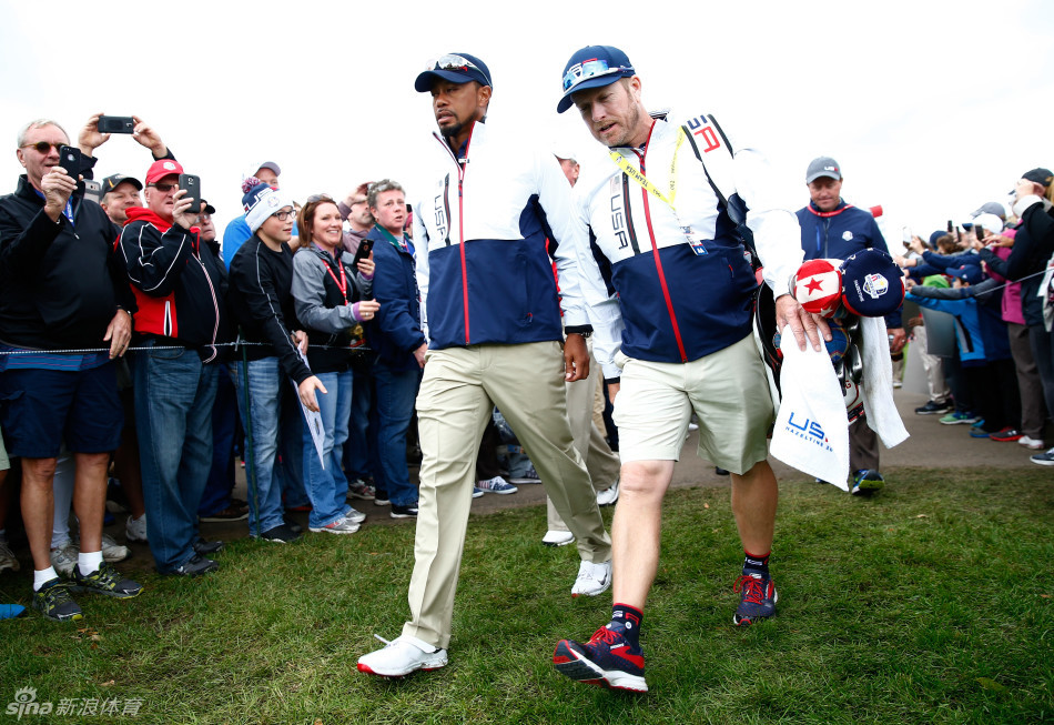 伍兹副队长与乔丹·斯皮思并肩而行,手指前方球场,似乎正在分享洞杯攻略与比赛心得