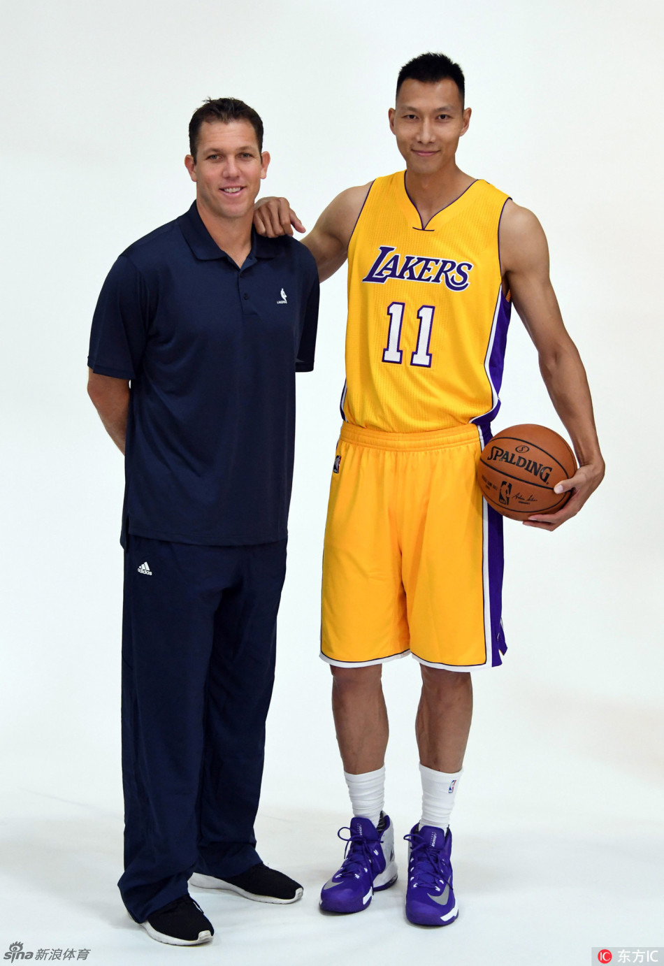 在黑白光影的交错中，易建联低头沉思，球衣上的湖人logo格外醒目，这一刻的静谧仿佛预示着暴风雨前的宁静。