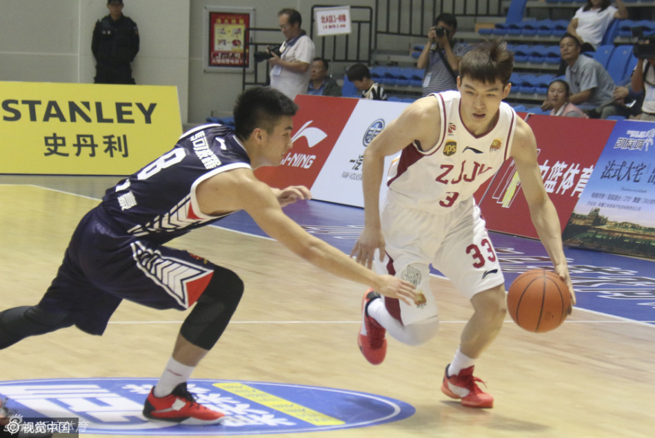 周琦现身赛场边，他身披外套，神情专注地看着场上发生的一切。即使作壁上观，他那独特的身高和天赋依然让他成为全场的焦点。