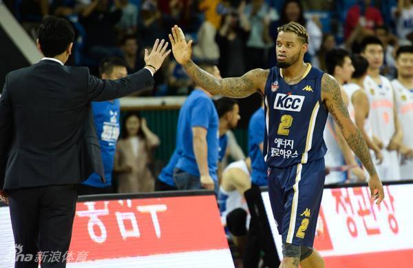 对方控卫面对防守沉着冷静，他一边娴熟地运球，一边伸出三根手指向队友示意战术，眼神中闪烁着指挥官的智慧光芒。