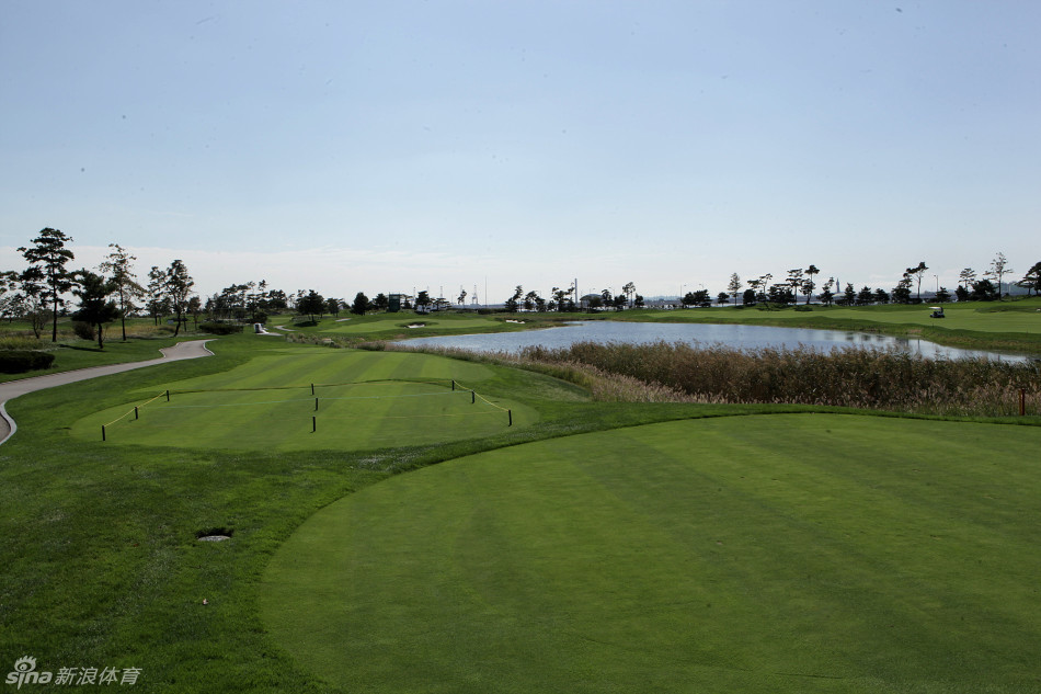 从10号洞发球台眺望，球道向着远方的山丘延伸，发球落点区域的沙坑在晨光中投下阴影，开启后九洞的征程。