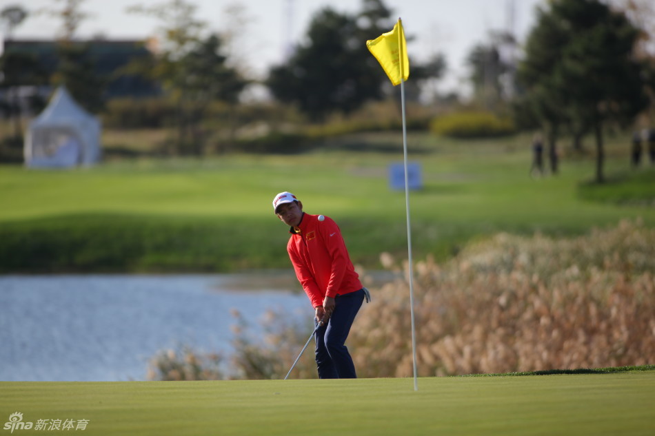 卫冕冠军金诚在球道上专注地进行击球准备，面对同组对手的强劲表现，他正努力调整自己的状态。