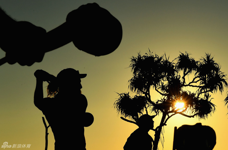 夕阳西下,一名球手面朝波光粼粼的大海挥杆练习,身影在金色余晖中宛如一位宁静的武士。