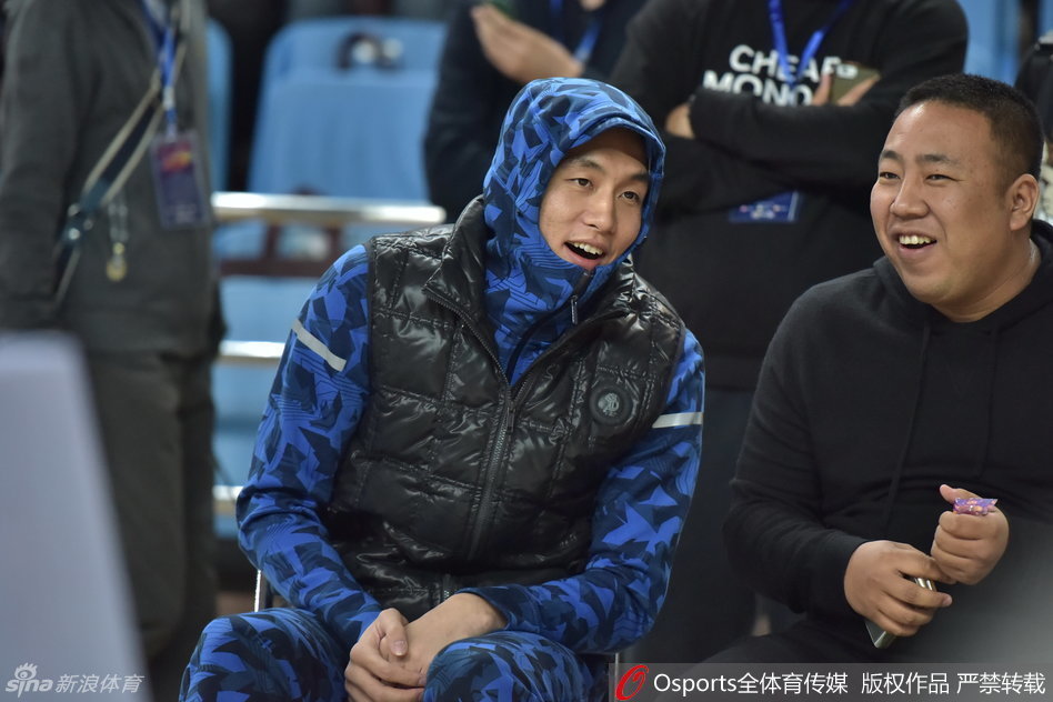 郭艾伦将羽绒服的帽子紧紧戴在头上，拉链拉到最高，整个人只露出一张脸，他轻轻撕开棒棒糖的包装纸，动作里透着几分迫不及待，仿佛一个在冬天偷偷享受零食的孩子。