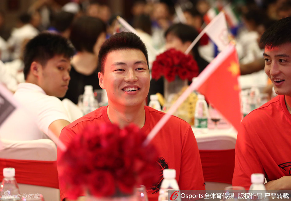 周琦嘴角上扬，露出标志性的腼腆笑容，眉眼间藏不住的开心感染了身旁的队友，仿佛将宴会厅变成了他的个人秀场。