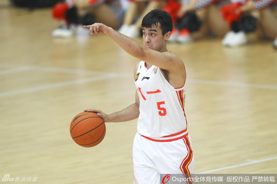 八一队后卫阿尔斯兰在场上伸出右手，比出战术手势，眼神犀利地调度着全队的进攻节奏。