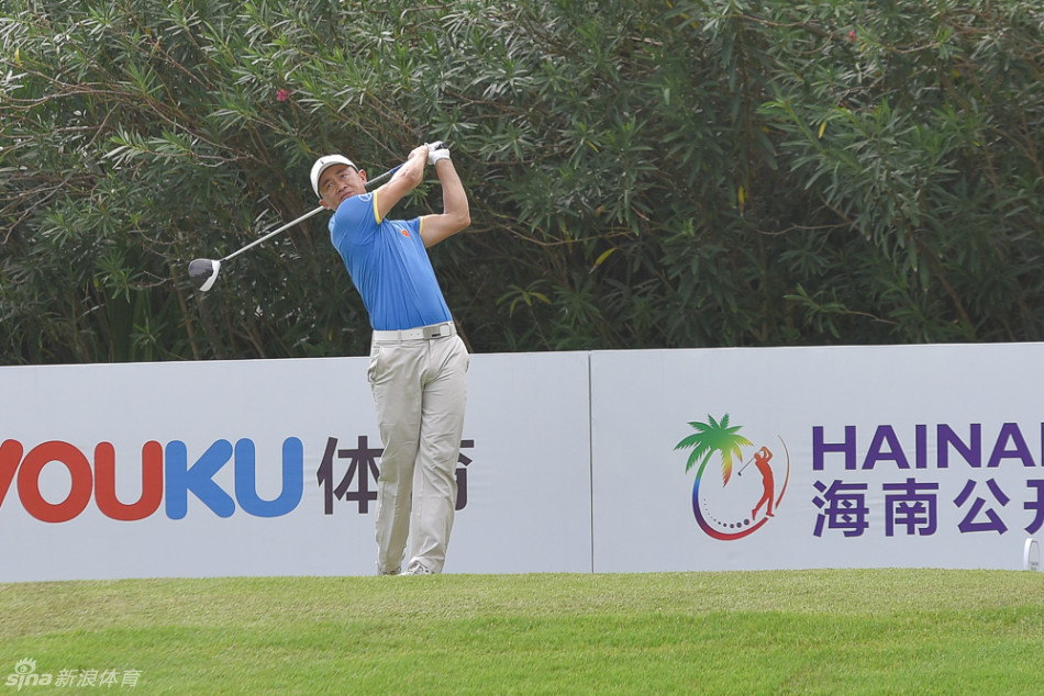 锦标赛现场，一位球员正使用长铁杆进行精准攻果岭击球，动作协调而稳定，背景中的球场标志清晰可见