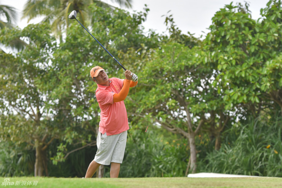 高尔夫球手在烈日下从容不迫地开球，他身后的球童撑着遮阳伞，两人都佩戴着专业防晒面罩，堪称球场上的全方位防晒典范