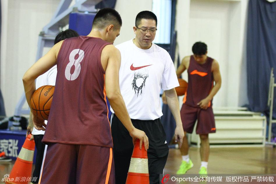 主帅胡卫东亲自上阵，在训练场上拉着一位年轻队员的面罩，神情严肃地进行战术布置，眼神中透露出对细节的极高要求。