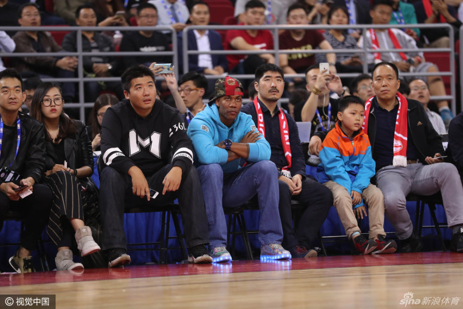 灯光璀璨的五棵松篮球馆内，马布里安静地坐在场边座椅上，眼神专注地凝视着赛场中央，仿佛在品味着昔日的NBA记忆。