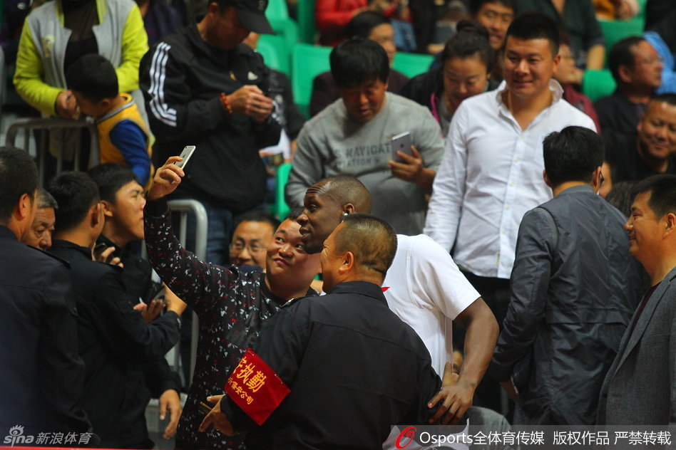 哈德森挤出人群与忠实球迷合影，闪光灯亮起记录下这珍贵的追星时刻