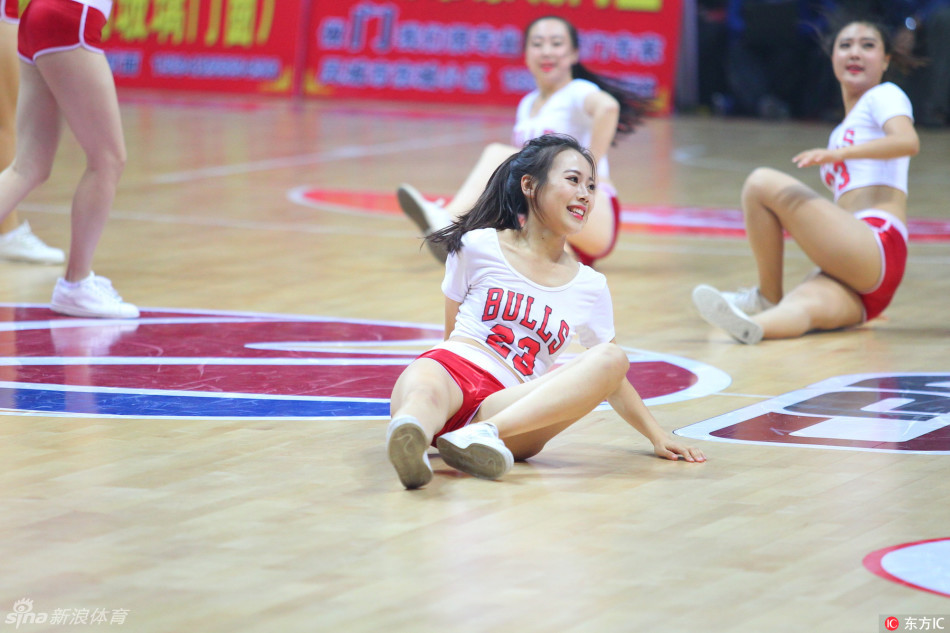 两名啦啦队员面对面热舞，脸上洋溢着灿烂笑容，紧身衣勾勒出窈窕身姿，动感瞬间被镜头定格