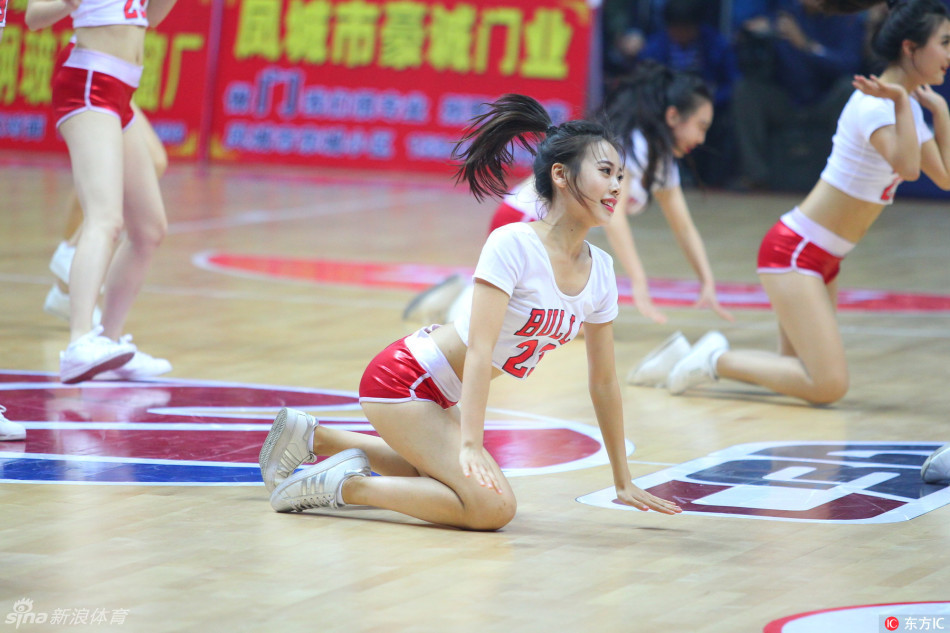 啦啦队集体摆出酷炫造型，队员一字排开高抬腿，动作整齐划一，充满力量感与视觉冲击力