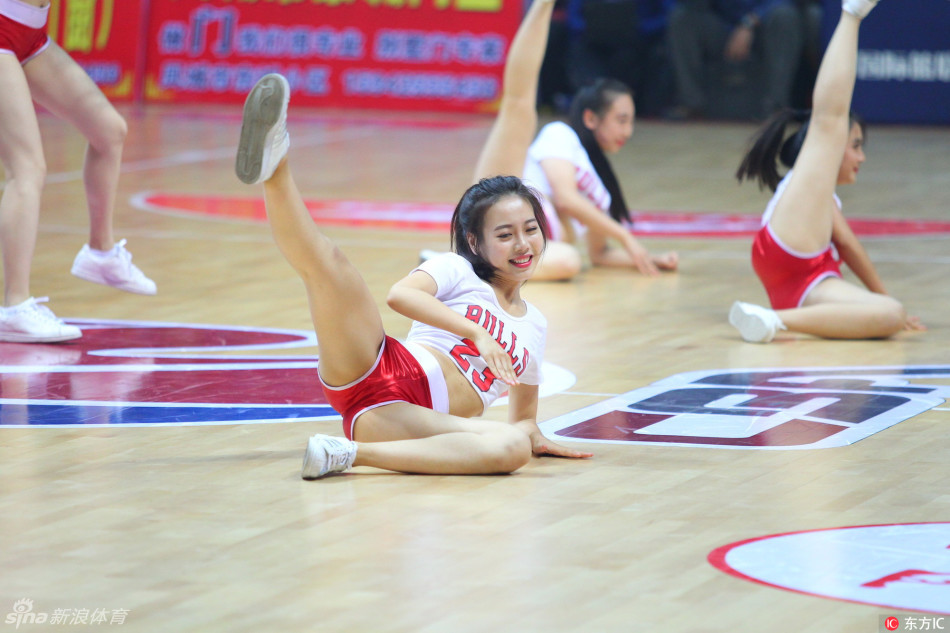 两名队员正进行高难度配合，前排队员下腰展示柔韧度，后排队员俯身互动，充满戏剧张力