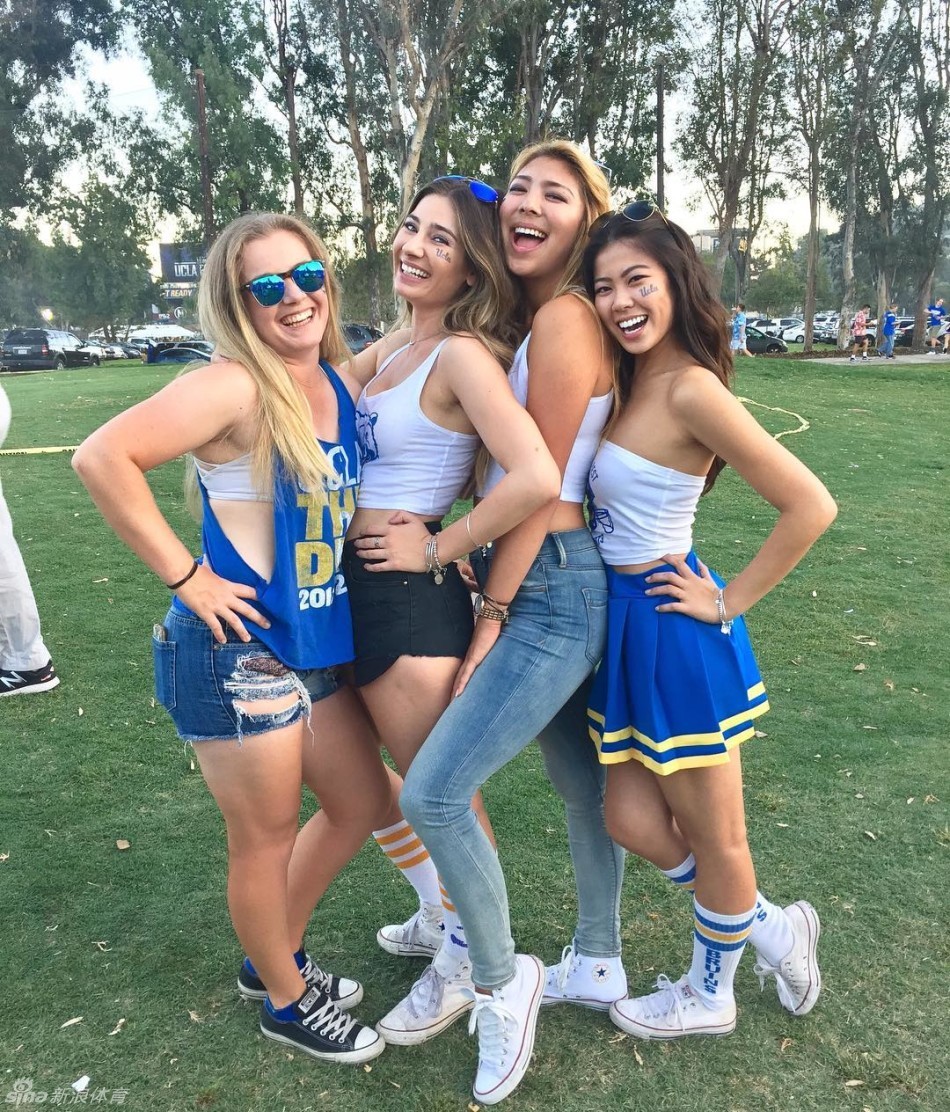 一位长发女生漫步在UCLA经典的罗伊斯礼堂红砖拱廊下，阳光穿过廊柱，在她身上投下斑驳的光影。