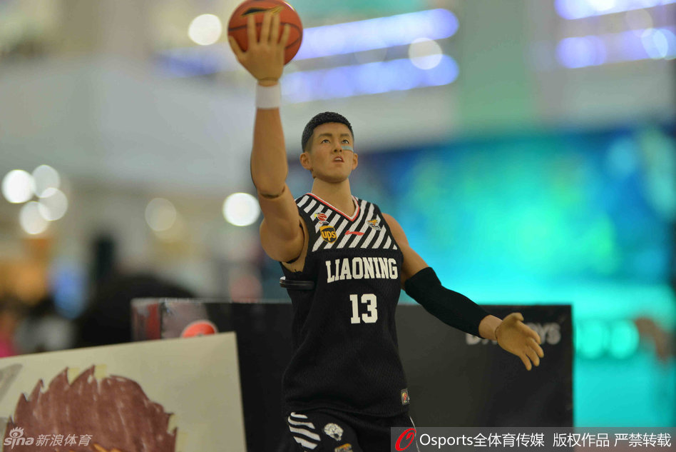 签售会现场，一位穿着时尚的年轻女孩双手抱着刚签售得到的郭艾伦人偶，在人潮中低头端详，脸上洋溢着满足的微笑，仿佛得到了全世界最珍贵的宝贝。