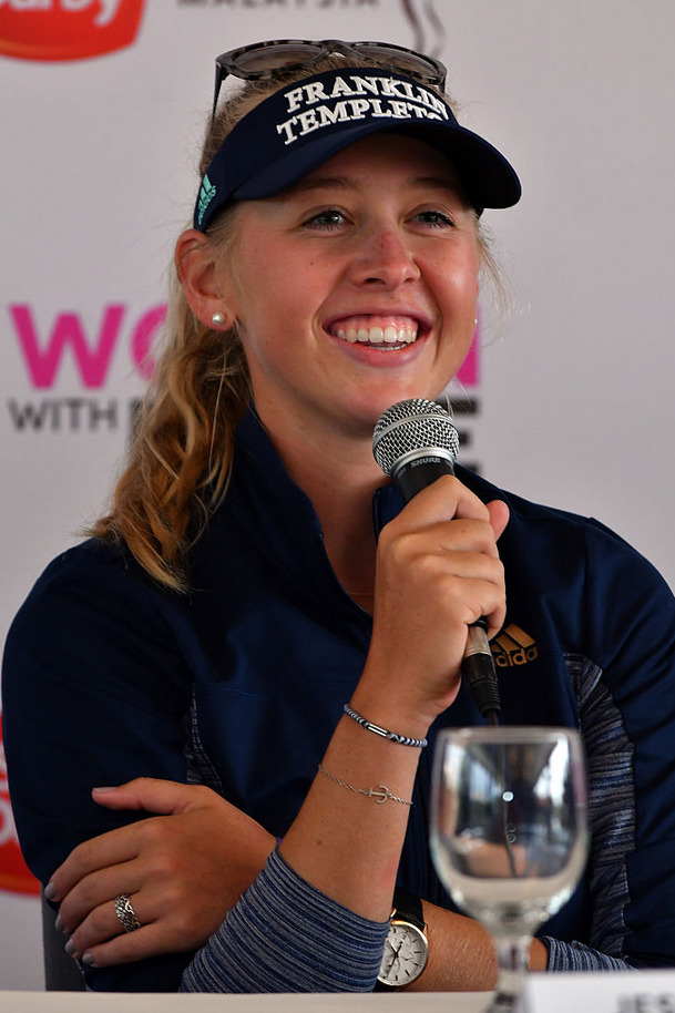 小魔女魏圣美在粉色沙坑中专注切杆，柔和阳光下沙粒泛起淡淡金辉，她身姿优雅从容不迫