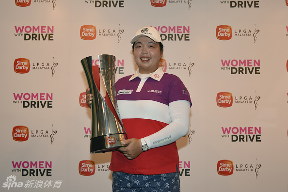 冯珊珊与赛事工作人员及嘉宾在果岭上亲切合影，她亲切地搂着同伴，现场气氛温馨而融洽。