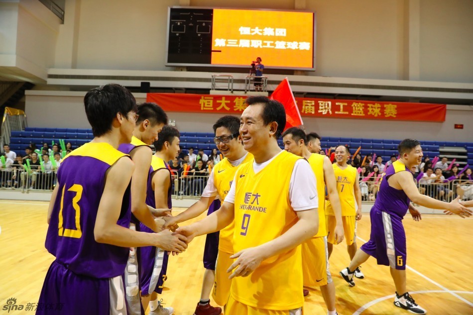 面对年轻员工的严密防守，许家印毫无惧色，他运球突破，身体微微后仰，以一个教科书般的姿势稳稳将球投出，眼神中透露出坚定与自信。