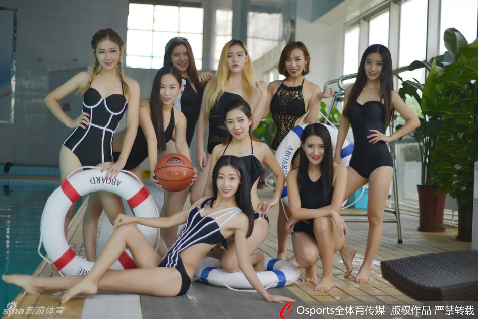 两位篮球宝贝在泳池中相视而笑，宛如一对并蒂而开的莲花。清澈的水花映衬着她们精致的面容，紧身的泳装勾勒出运动员般优美的身体线条，展现出姐妹花般的亲密与默契。