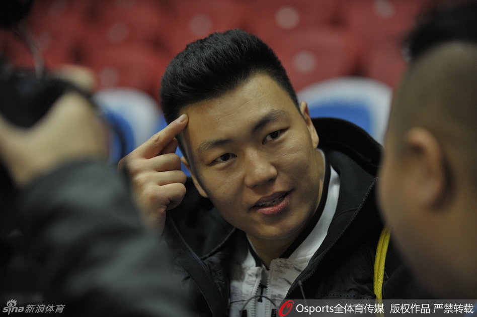 李根将手指抵在额头，仿佛在思考着战术板上的奥秘，又像是在向队友发出一个无声的信号，型男气质尽显无遗。