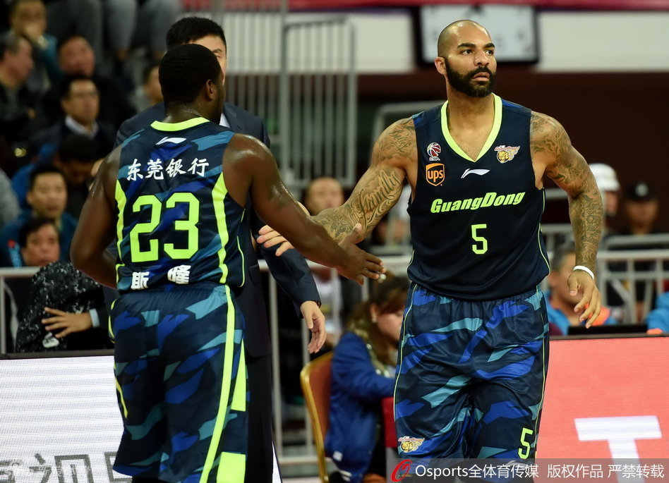 卡洛斯·布泽尔扬起手臂，与队友唐纳德·斯隆用力击掌，两人眼神中充满战斗的欲望，仿佛在无声地宣告：属于我们的时刻到了！