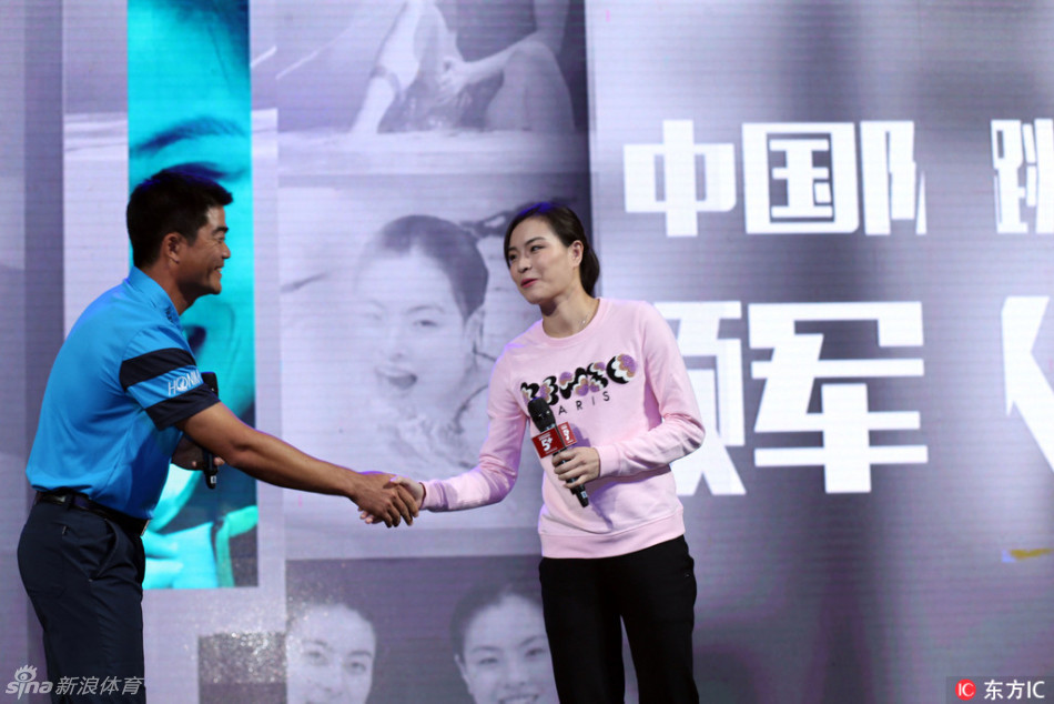 梁文冲微微俯身,正专注地指导吴敏霞推杆的手部姿势与角度,教学氛围认真而融洽