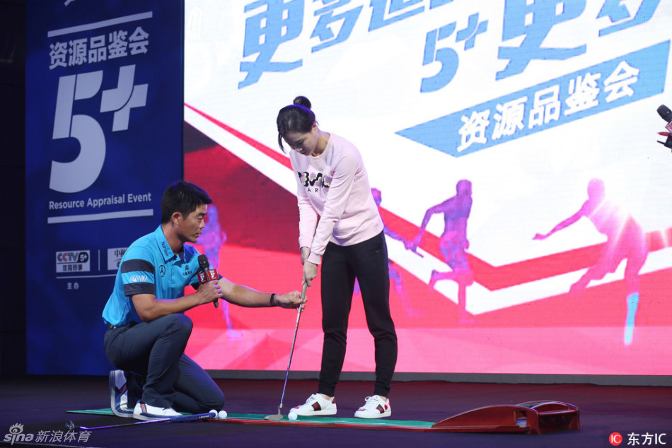 活动全景定格,梁文冲与吴敏霞手持推杆并肩而立,共同面向镜头,身后是活动主题背景板