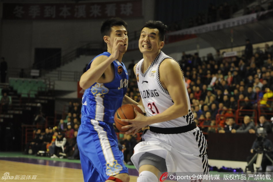 曹飞面对赵继伟的紧逼防守，压低重心运球，眼神余光扫视着场上队友的跑位，力求稳稳掌控比赛节奏。