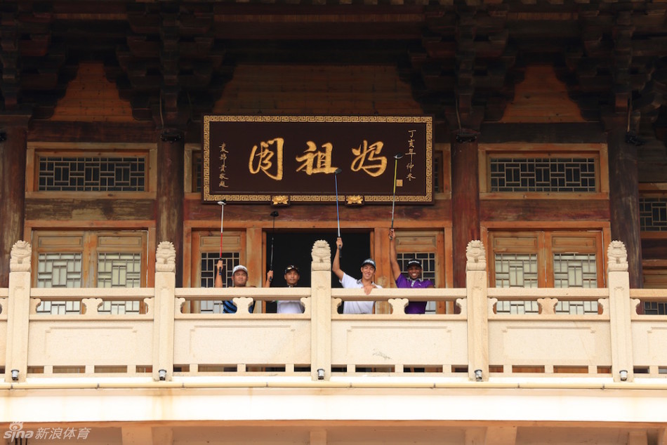 白色高尔夫球在碧绿草地上静静停留，背景是妈祖阁的一角，构成一幅静物般的和谐画卷。