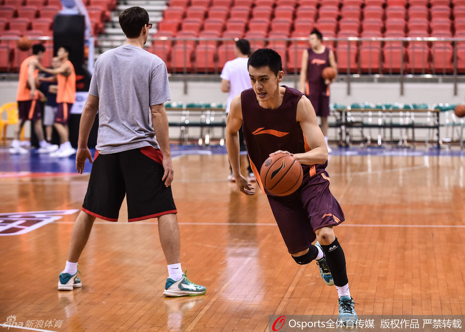 队长杨鸣在训练中神情严肃，举手示意战术跑位，作为球场大脑的他正耐心梳理着球队的攻防节奏