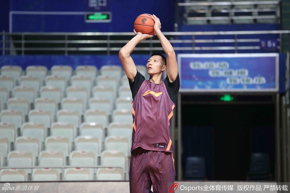 董瀚麟在内线双手持球，眼神余光扫视着队友的跑动路线，准备将球巧妙地传给切入篮下的易建联，完成一次精彩的配合。