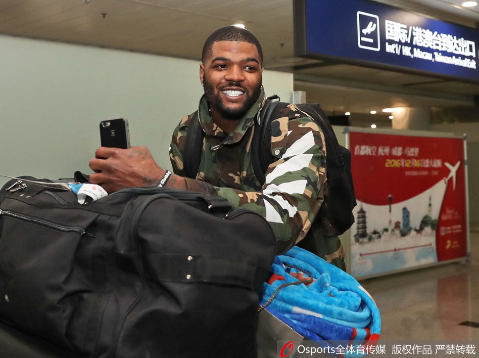 约什的妻子亚历桑德里亚静静站在一旁，目光温柔地注视着正在为球迷签名的丈夫，一家三口的温馨氛围在繁忙的机场大厅中弥漫开来。