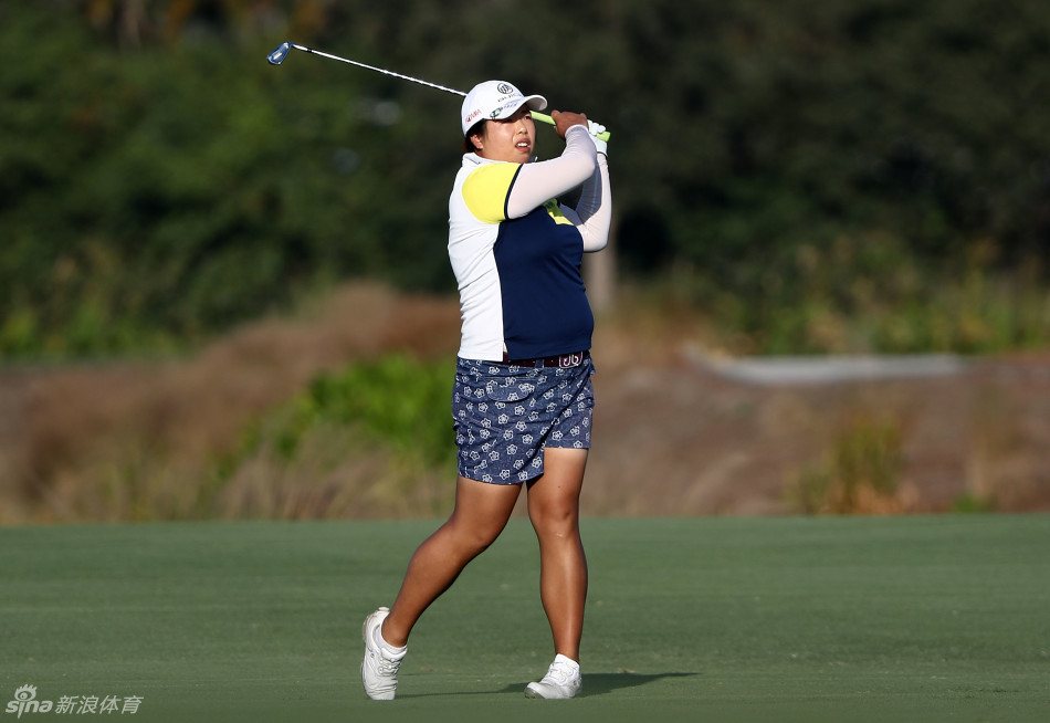 冯珊珊在果岭上全神贯注地观察推杆线路，眼神坚定而冷静，冠军气质尽显。