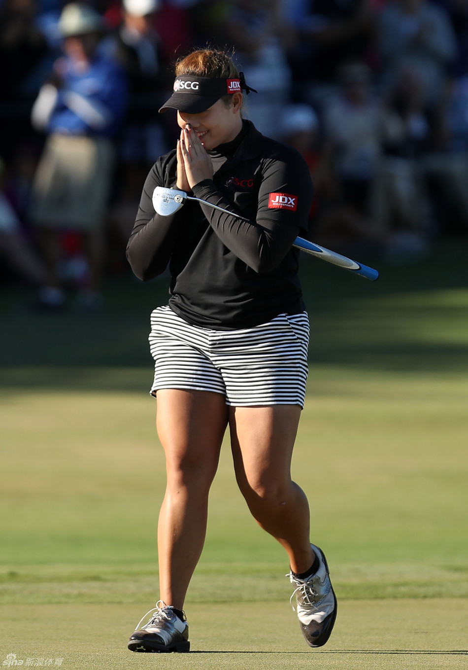 颁奖典礼上，冠军查莉·赫尔高举奖杯，银色奖杯与身后夜色中的赛事标识交相辉映