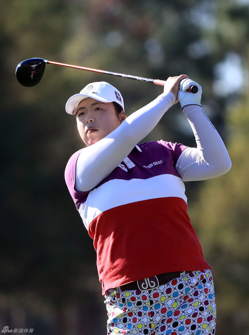 中国选手冯珊珊在球道上稳健挥杆，身姿挺拔，目光专注地望向远方落点