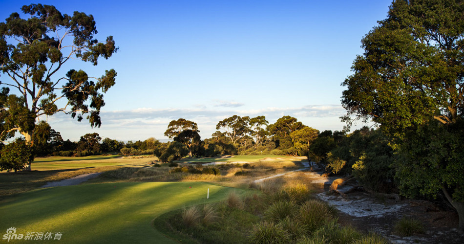 高尔夫球划出一道优雅的抛物线,飞越蔚蓝的湖水障碍飞向果岭