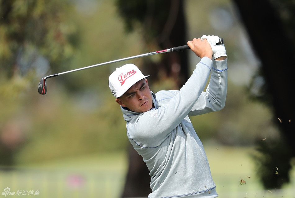 一位坐在轮椅上的残障人士在职业球手的鼓励下，满怀信心地准备挥杆击球。