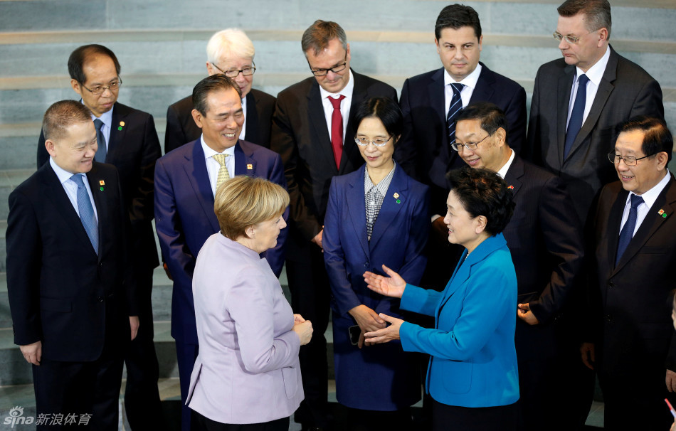 刘延东副总理与默克尔总理在柏林总理府亲切握手，两国代表在身后一字排开，共同见证中德足球合作的珍贵历史瞬间，现场氛围庄重而充满期待。